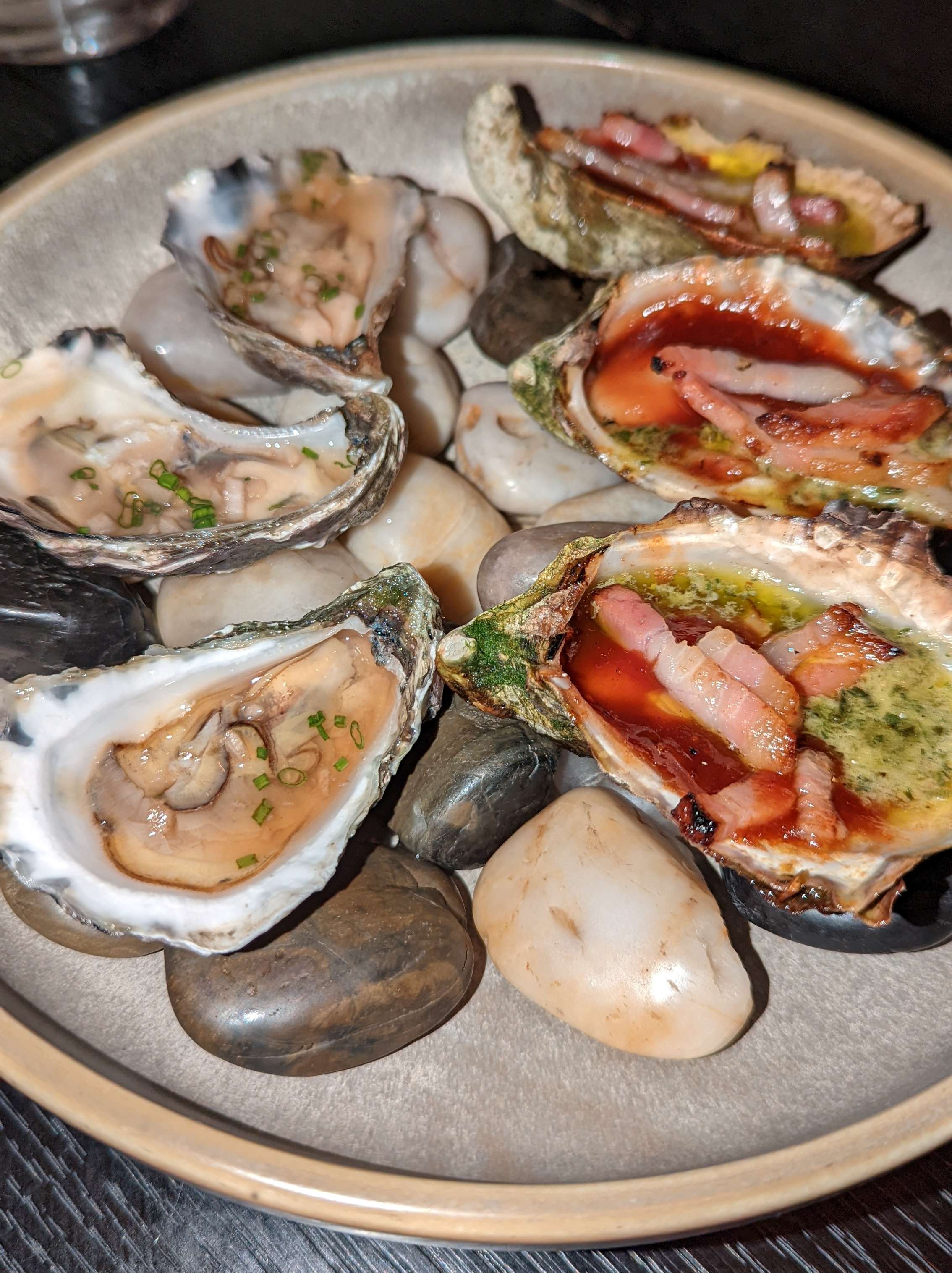 A plate of oysters on cold rocks, half natural and half with toppings. Taken during an evening at Nineteen at The Star.